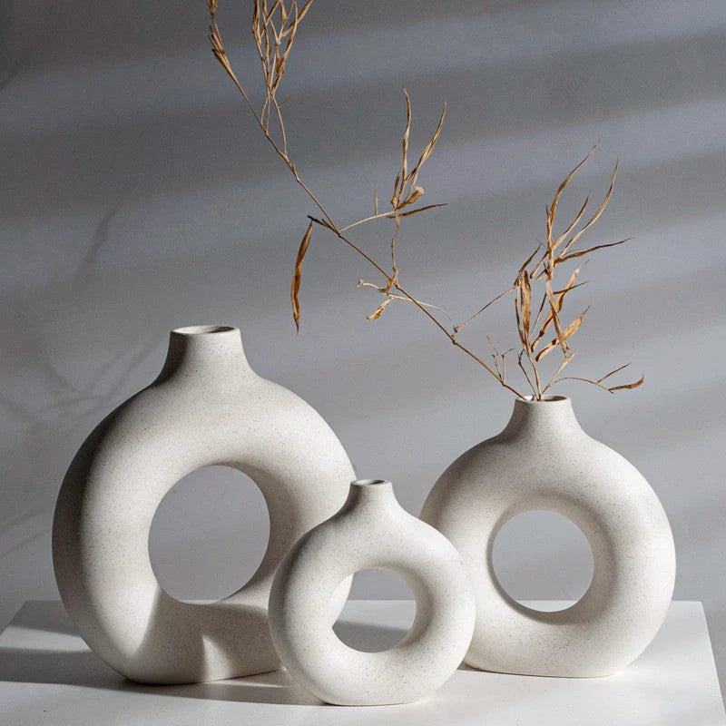 Elegant circular ceramic vase with a hollow, minimalist design for displaying flowers or as a standalone décor piece