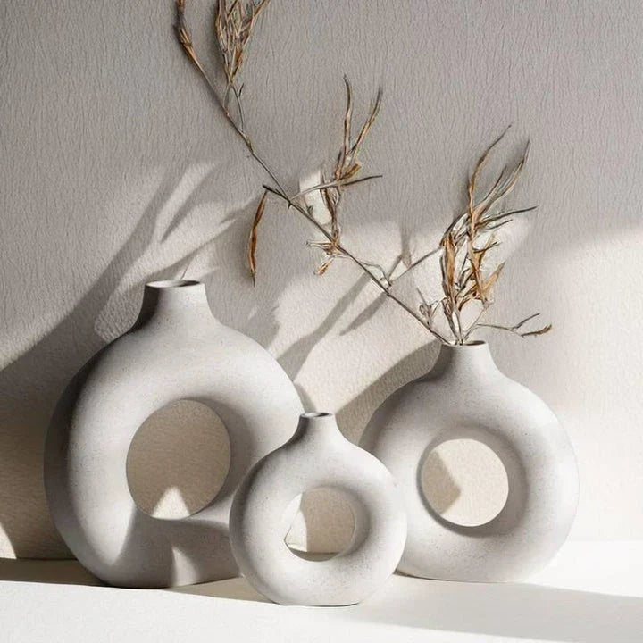 Elegant circular ceramic vase with a hollow, minimalist design for displaying flowers or as a standalone décor piece