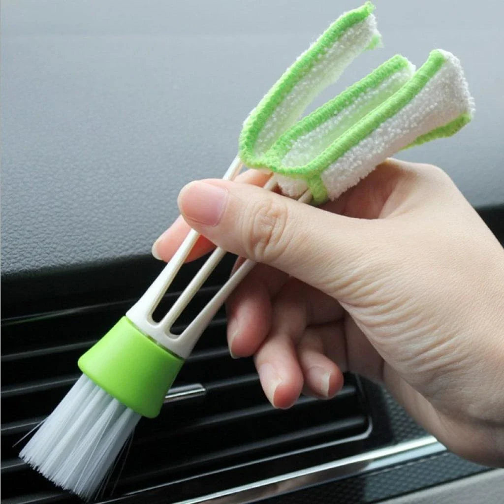 A black car air vent cleaning brush with soft bristles and a microfiber towel end for thorough vent cleaning.