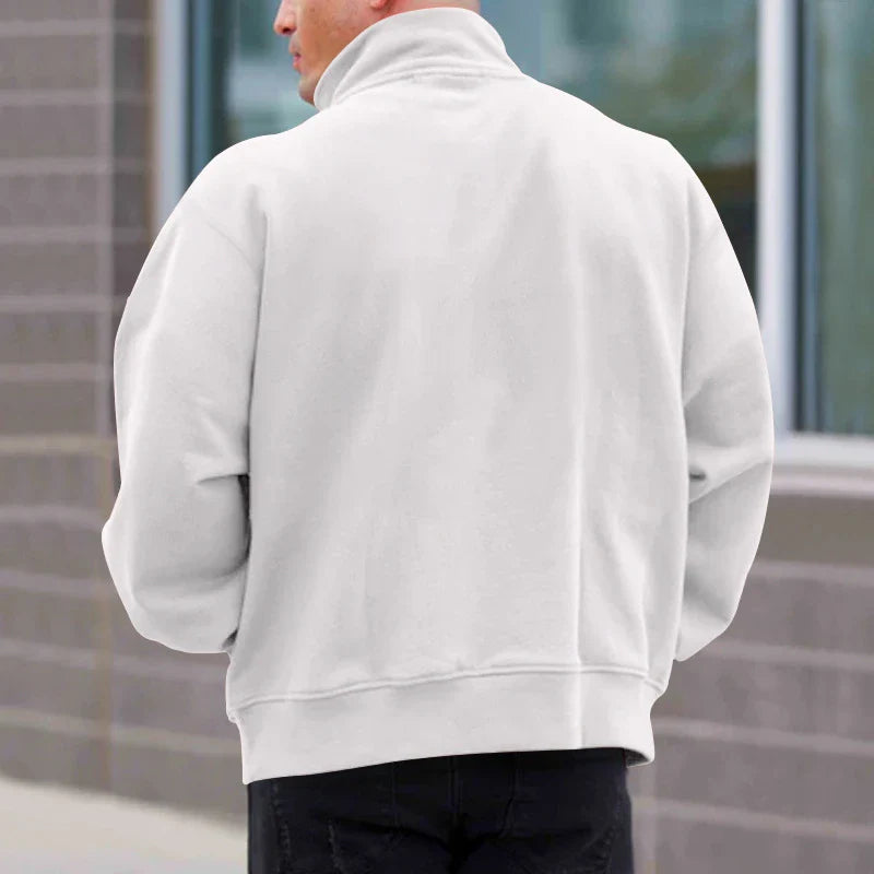 A man wearing a comfortable, fleece-lined long sleeve pullover in a solid color.