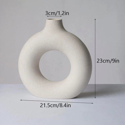 Elegant circular ceramic vase with a hollow, minimalist design for displaying flowers or as a standalone décor piece