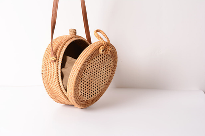 A collection of hand-woven tropical straw purses in various shapes, sizes, and designs, perfect for Kiwi summer style.