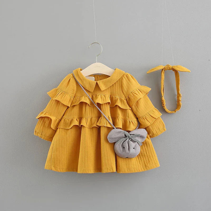 A beautiful baby girl summer dress with a princess silhouette, accessorized with a matching bag and hairband.