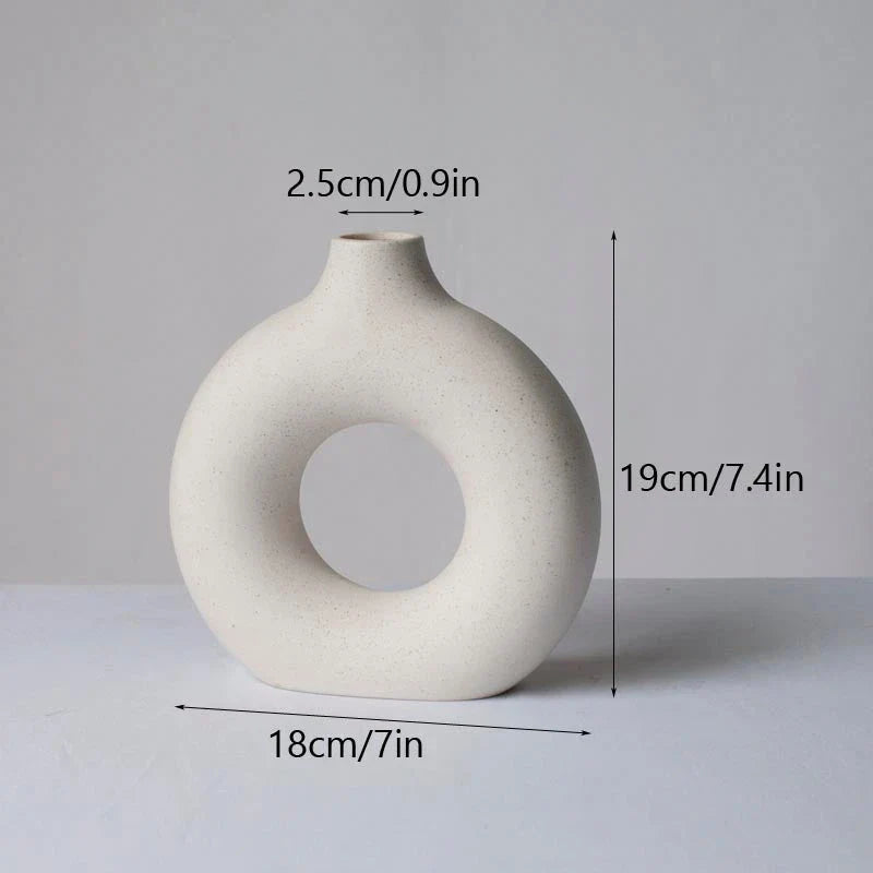 Elegant circular ceramic vase with a hollow, minimalist design for displaying flowers or as a standalone décor piece