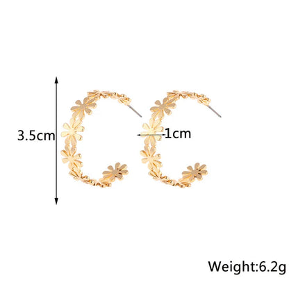 A pair of golden geometric c-shaped flower drop earrings, a timeless New Zealand fashion accessory