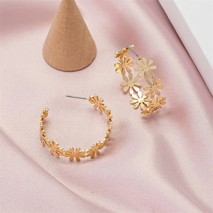 A pair of golden geometric c-shaped flower drop earrings, a timeless New Zealand fashion accessory