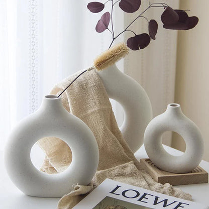 Elegant circular ceramic vase with a hollow, minimalist design for displaying flowers or as a standalone décor piece