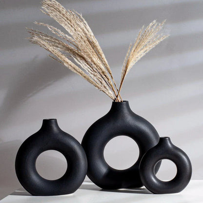 Elegant circular ceramic vase with a hollow, minimalist design for displaying flowers or as a standalone décor piece