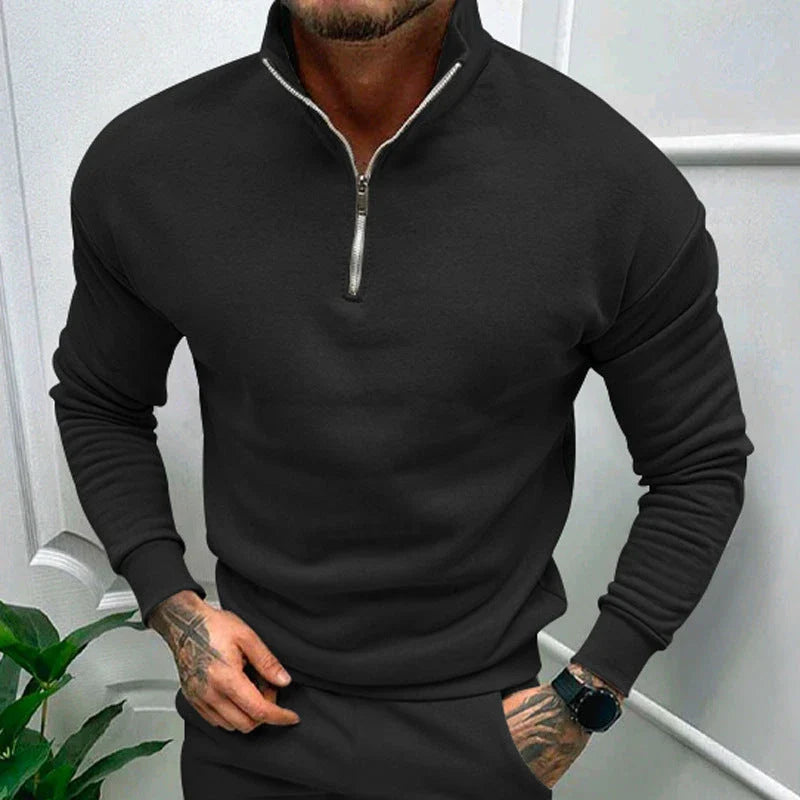 A man wearing a comfortable, fleece-lined long sleeve pullover in a solid color.